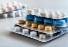 Blister Pack Advancements in Pharmaceutical Packaging Stacked blister packs containing blue, yellow, and white pills on a reflective surface, ready for dispensing